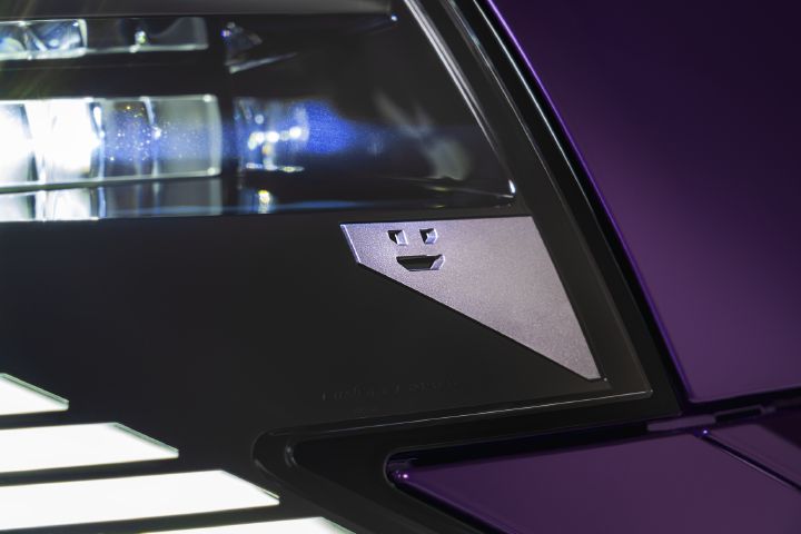 Närbild av Nissan PIXO:s framstrålkastare, med ett litet robotansikte-motiv integrerat i belysningsdesignen.