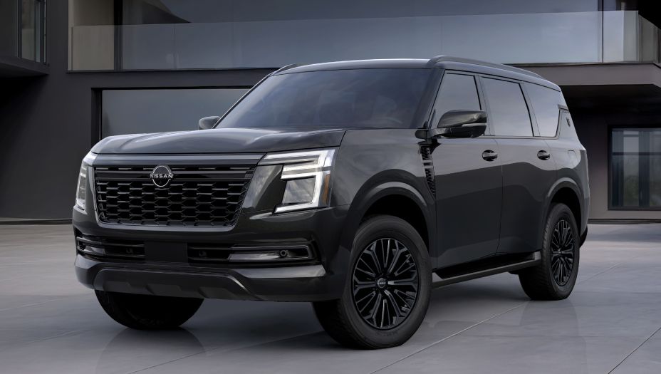 Front left 3/4 view of the 2027 Nissan Armada Dark Armor parked in front of a modern building.