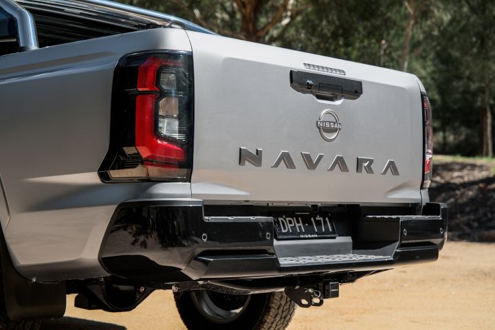 2026 Nissan Navara ST dual cab ute finished in Summit Silver shown in a rear close-up with NAVARA tailgate embossing, left tail-light, black bumper step and tow hitch.