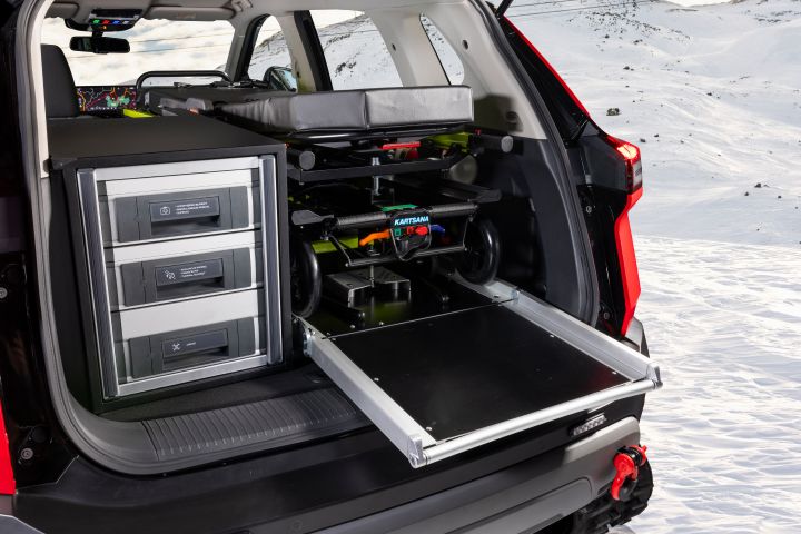 The interior of the trunk containing a stretcher and some boxes including emergency material