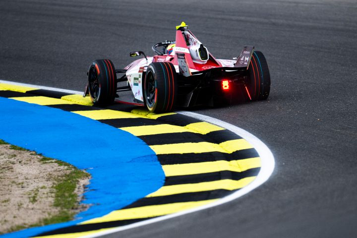 Rückansicht von Oliver Rowland, wie er mit dem Nissan e‑4ORCE 05 mit der Startnummer 1 durch eine Kurve fährt.