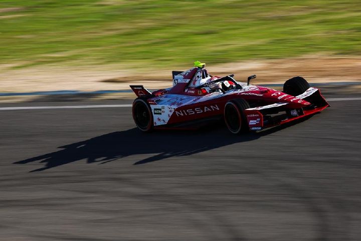 Carro de corrida da equipe Nissan de Fórmula E fazendo uma curva em uma pista de corrida