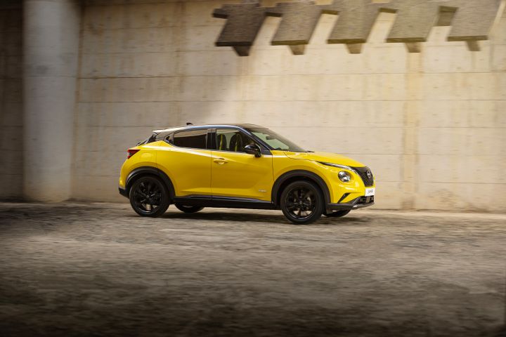 Seitliche Fahraufnahme gelber Nissan Juke auf hellem Untergrund vor hellem Hintergrund