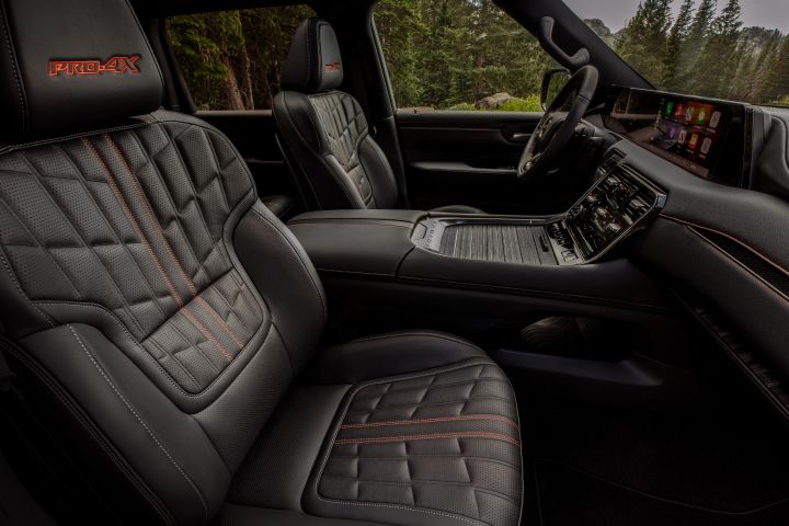 The black leather front seats with quilted stitching viewed from the passenger door of a 2025 Nissan Armada.