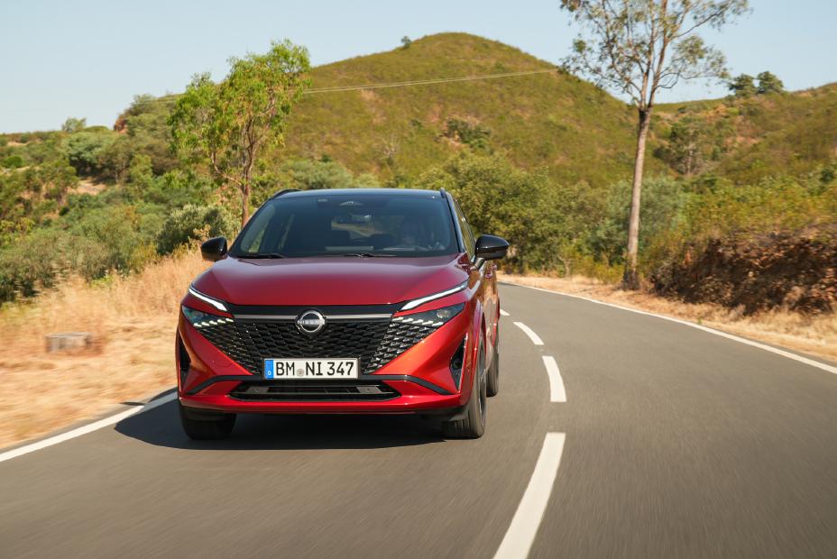 Front view of New refreshed Qashqai 2024 showing grille in fuji sunset color driving on the road in Faro, Portugal
