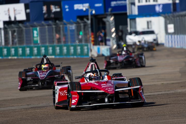 Frontalaufnahme von Norman Nato am Steuer des Nissan Formel E Rennwagens mit der Startnummer 23 in Berlin, hinter ihm mehrere andere Fahrzeuge.