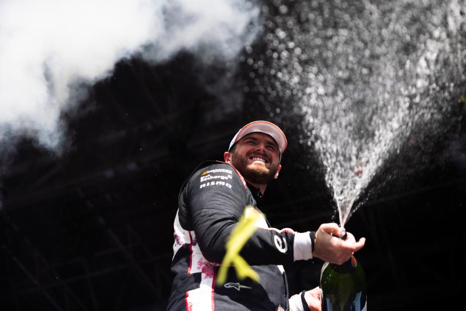 Oliver Rowland celebrates by spraying champagne on the Berlin podium