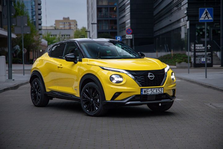 Żółty Nissan Juke stojący półprofilem na tle budynków