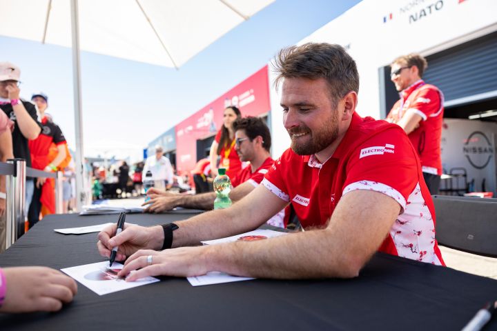 Oliver Rowland gibt einem Fan in Berlin ein Autogramm