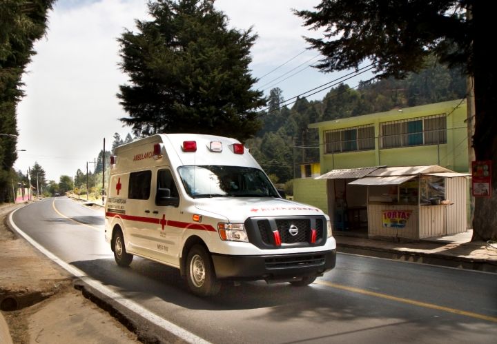 Una ambulancia Nissan NV2500 junto a una residencia