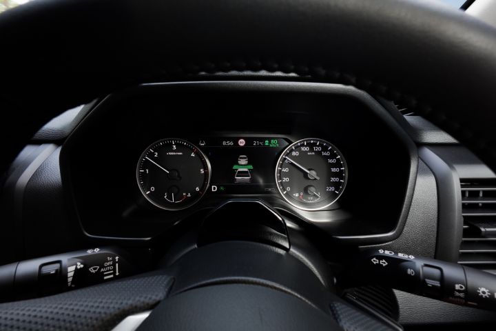 Driver’s-eye view of the 7-inch TFT Display Instrument Cluster in a 2026 Nissan Navara ST‑X, showing a lane-keeping or driver-assistance graphic with a vehicle icon centred between analogue gauges.