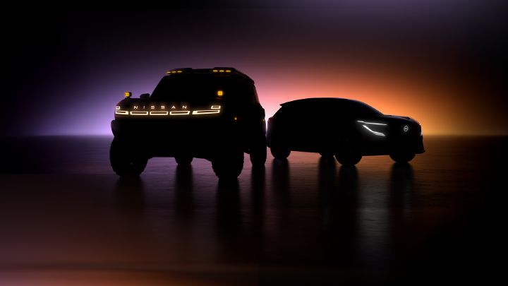 Imagem de dois carros-conceitos em um ambiente escurecido que não revela suas linhas, com apenas luz de fundo e dos faróis acesos