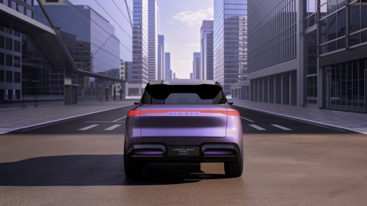 Rear view of a purple Urban SUV PHEV Concept with tall buildings lining both sides of the road.