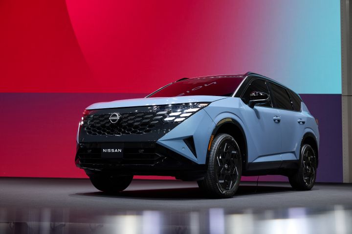 lower front left 3/4 angle of the 2027 Nissan Rogue Hybrid e‑POWER on a stage.