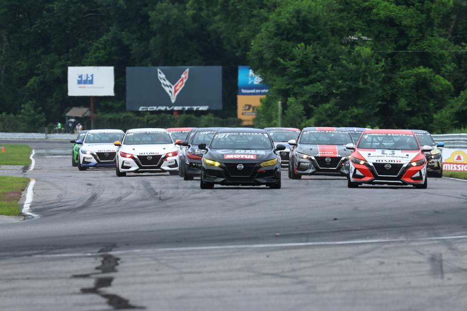 All Nissan Sentra Cup drivers on the Lime Rock track during a race at Lime Rock Park with trees in the background