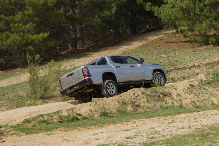 2026 Nissan Navara ST dual cab ute finished in Summit Silver shown head-on at the crest of a sandy off-road descent.