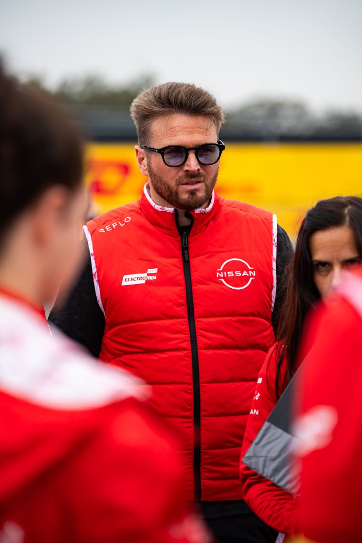 Porträtfoto von Oliver Rowland mit seiner roten Nissan Formula E Team-Weste und seiner Sonnenbrille während des Streckenrundgangs auf dem Miami International Autodrome.