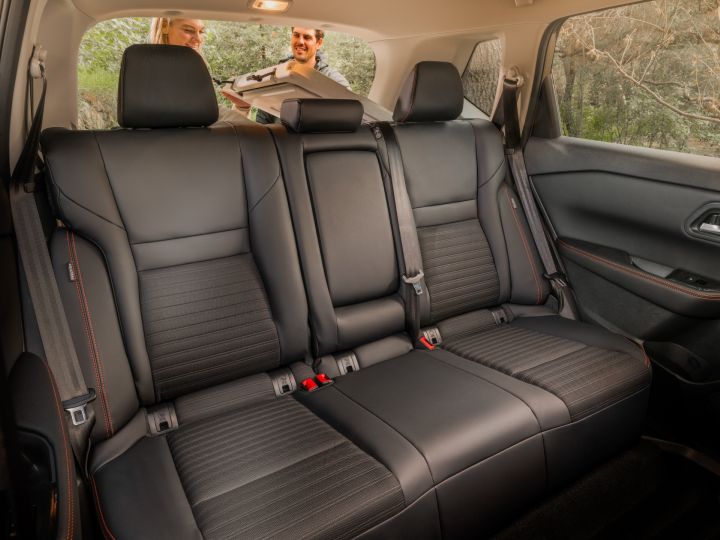 The black back passenger seats inside the 2025 Nissan rogue rock creek, there is red stich detailing.