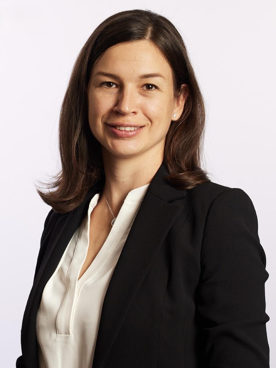 Porträtfoto von Liza Martinek in weißer Bluse mit dunklem Blazer und mit schulterlangen braunen Haaren
