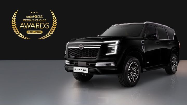 A black Nissan Patrol SUV displayed on a reflective surface with a dark background, positioned to the right. To the left is a gold laurel emblem showing the AutoFocus Media’s Choice Awards 2025–2026.
