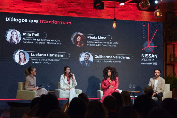 Quatro pessoas sentadas em um palco à frente de um painel com os nomes e Diálogos que Transformam escrito em vermelho