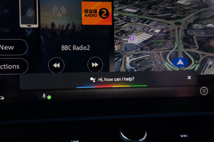 Close-up of the Nissan X‑Trail infotainment touchscreen, displaying navigation, media playback and voice assistant functionality.