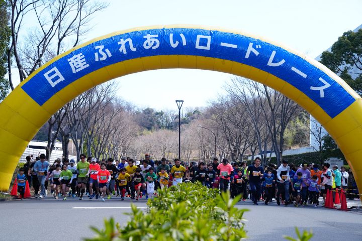 Runners and accompanying runners wait at starting line from straight angle