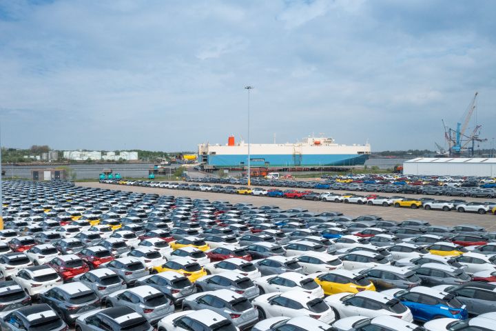 Nissan Autoterminal im Hafen von Tyne mit vielen geparkten Fahrzeugen vor einem Autotransporter-Schiff