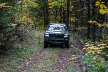 Vue de face d’un Nissan Frontier 2022 vert roulant sur un sentier.