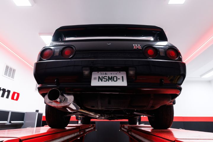 A close up of the rear of a black R32 GT‑R in the workshop of the new NISMO Performance Centre Melbourne.