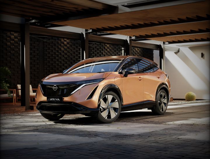 Static front ¾ image of a copper 2025 Nissan Ariya SUV electric vehicle parked on a pavement