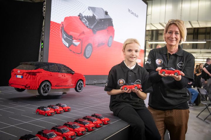 Friederike Kienitz and a school child holding a small LEGO Nissan Qashqai