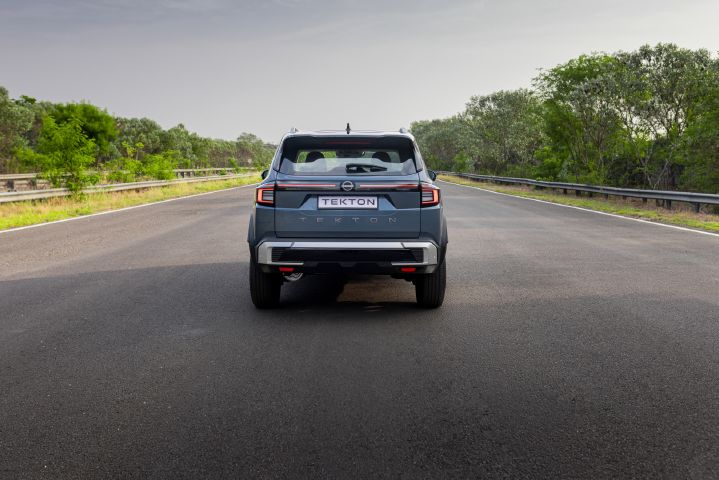 Rear view of the Nissan Tekton centred on a road, highlighting the full-width rear light bar and tailgate styling.