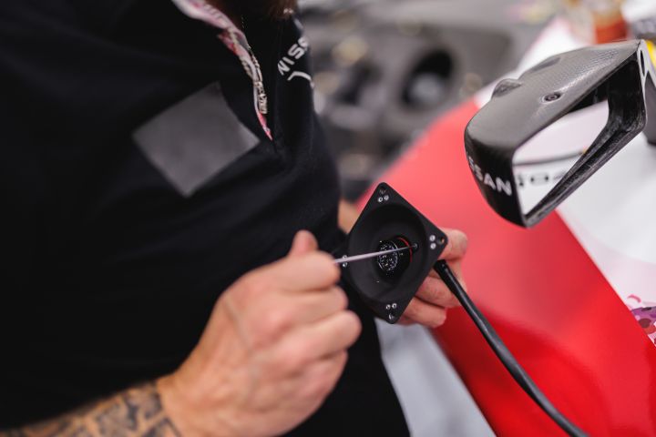 Nahaufnahme auf die Hände eines Mechanikers, der ein Teil festschraubt