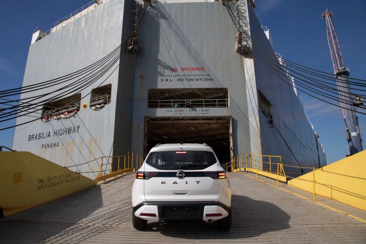 Nissan Kait branco sobe a rampa que dá acesso ao navio cinza chamado Brasilia Highway, do Panamá