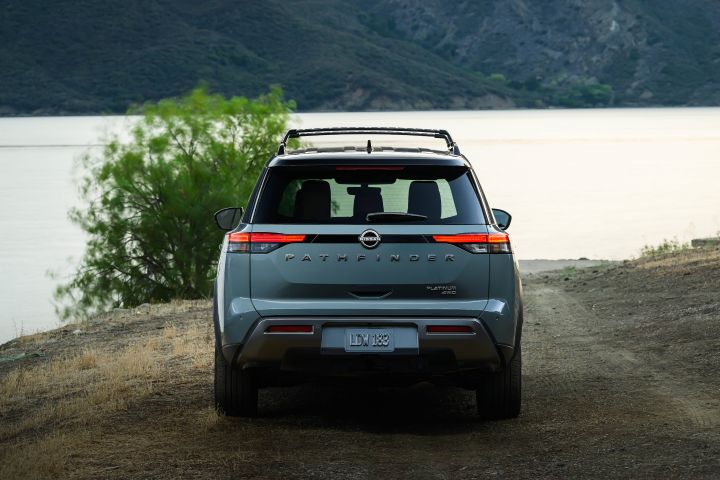 Rear view of the 2026 Nissan Pathfinder parked in front of a body of water at dusk.