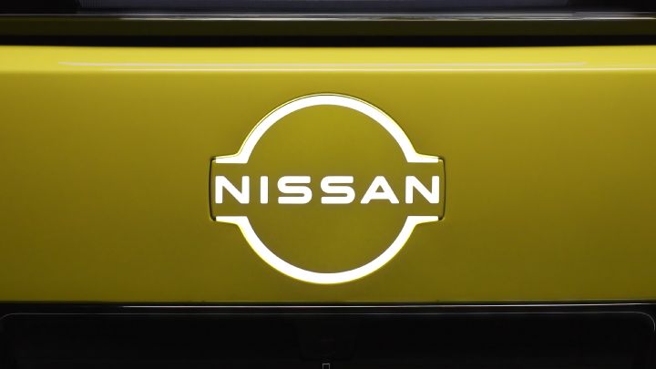 Close-up of an illuminated Nissan badge on a yellow car
