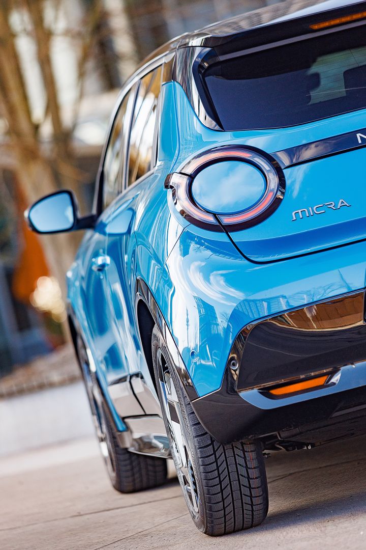 Detailansicht von Heck und linker Fahrzeugseite eines leuchtend blauen Nissan Micra mit schwarzem Kontrastdach