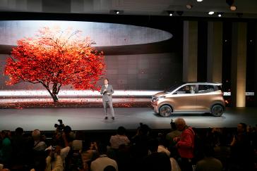 A man on stage presenting the IMk concept at the Tokyo Motor Show Press Conference