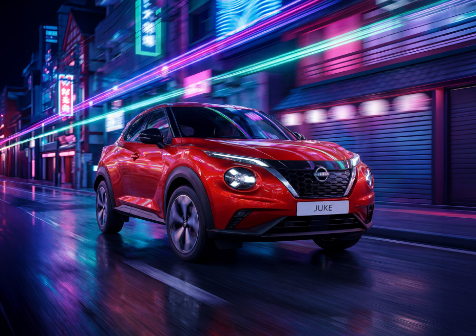 Czerwony Nissan Juke jadący nocą przez miasto, w dynamicznym ujęciu z neonowymi światłami w tle.