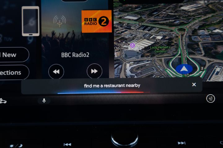 Close-up of the Nissan X‑Trail infotainment touchscreen, displaying navigation, media playback and voice assistant functionality.