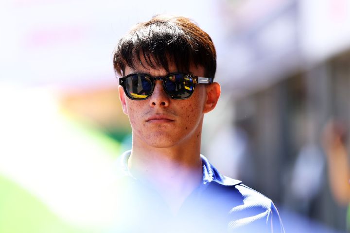 Zane Maloney an der Rennstrecke, während er eine Sonnenbrille und ein blaues Polohemd trägt.