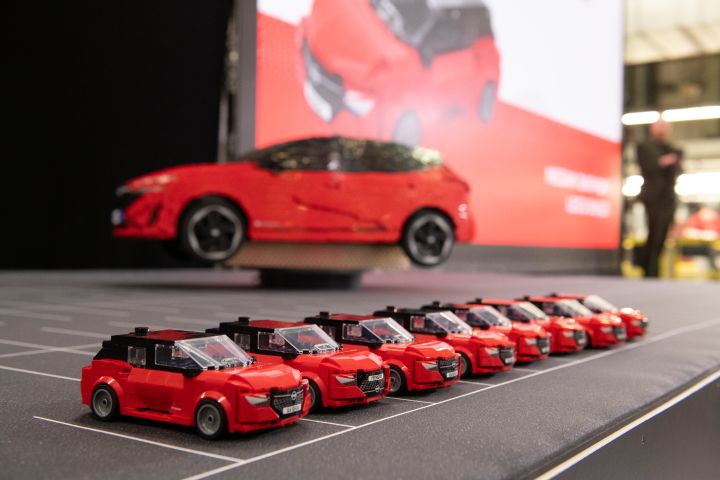 Big Nissan Lego Qashqai on a rotating platform with smaller Nissan Lego Qashqai lined up on a parking