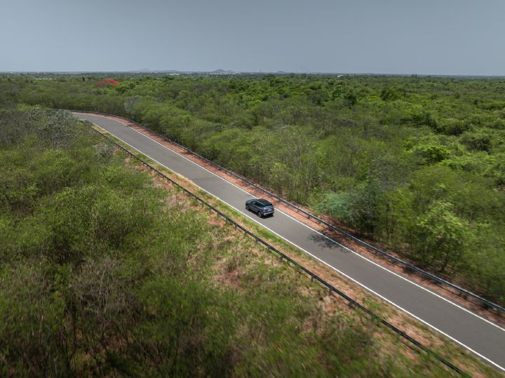 Aerial view of the Nissan Tekton travelling along a road surrounded by greenery.