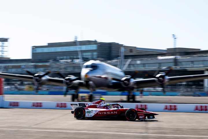 Oliver Rowland auf der Rennstrecke in Berlin, im Hintergrund ein großes Flugzeug