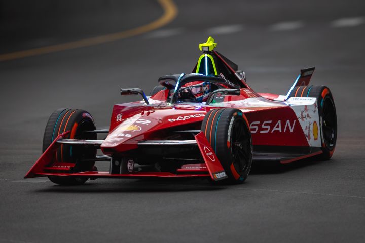 De rode raceauto van Nissan Formule E-coureur Oliver Rowland op het circuit terwijl hij Sainte Devote nadert tijdens de E-Prix van Monaco