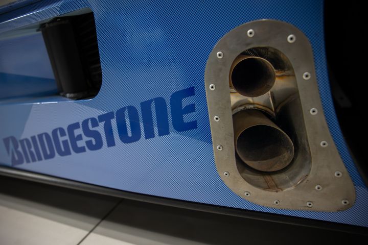 A close up of the exhaust on a blue Nissan R390 GT1 Le Mans race car shown within the Nissan global gallery in Yokohama, Japan.