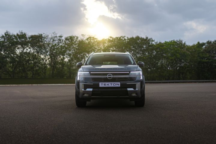 Front view of the Nissan Tekton with LED daytime running lights illuminated against a sunset backdrop.