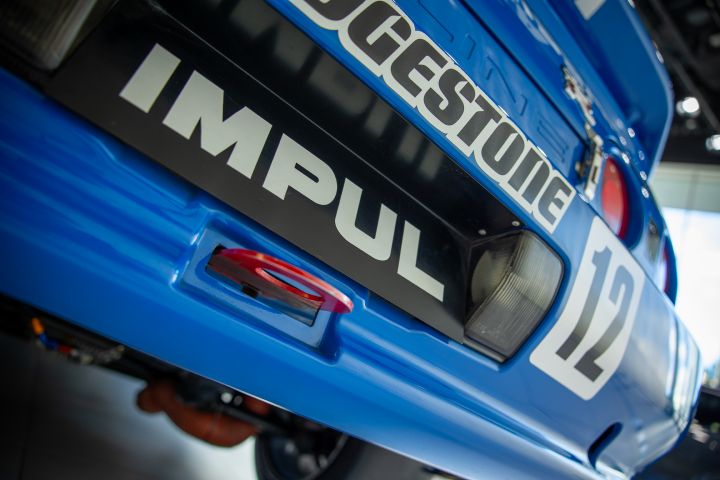 A close up on the lower rear of a blue NISMO GT‑R with number plate "IMPUL"