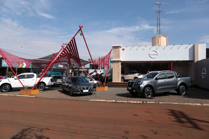 Vista frontal do estande da Nissan na ExpoLondrina com modelos como Versa e Frontier expostos em primeiro plano